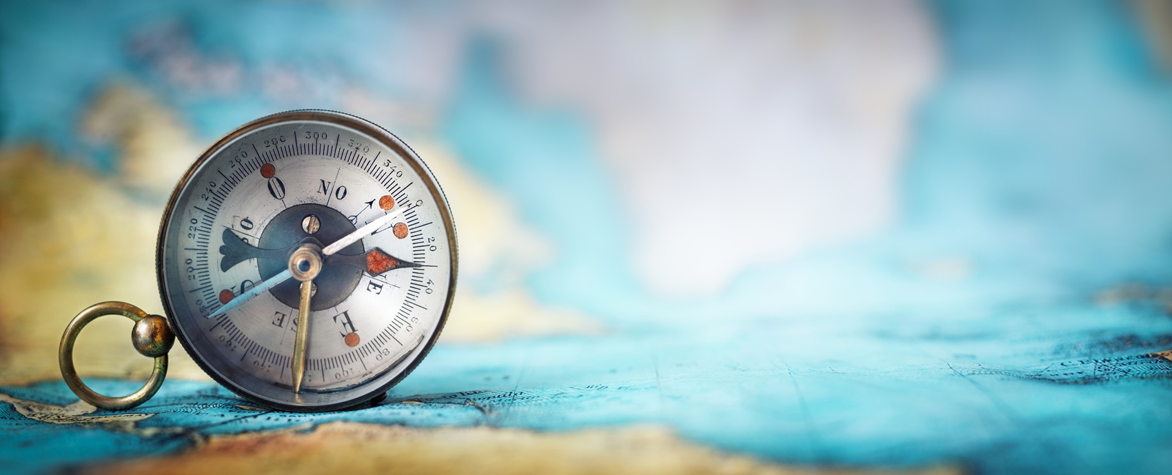 magnetic old compass on world map.travel, geography, navigation, tourism and exploration concept wide background. macro photo. very shallow focus.